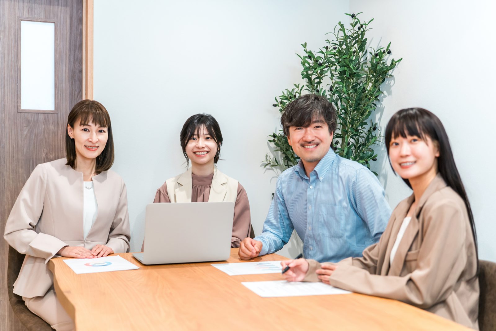 テーブルを囲んで打ち合わせをする社員